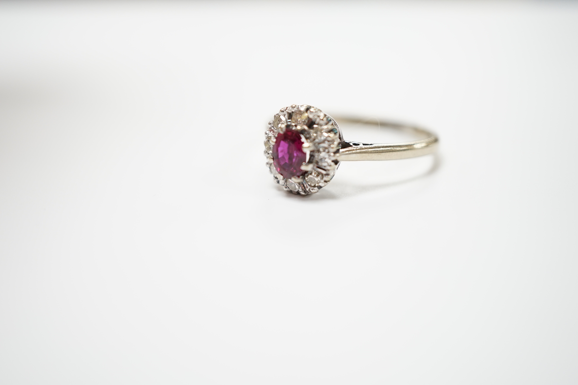 A 18ct white, ruby and diamond set oval cluster ring, size Q/R, gross weight 4.2 grams.